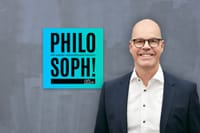 Podcastcover „Philosoph! Der andere Versicherungspodcast“ mit Arndt Bickhoff vor grauer Wand.