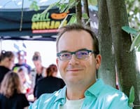 Mario Bergmann vor einem Stand der Grillninjas