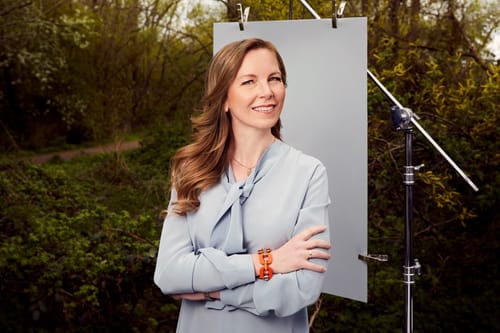 Stefanie Hauer steht vor einer Leinwand in einem Garten.